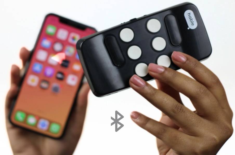 Bilde av hender som holder en Hable One-tastatur og en iPhone